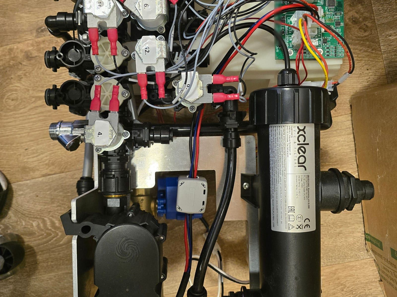 Waterunit met magneetkleppen, slangen, een UV-lamp en een groene print van ProCircuits